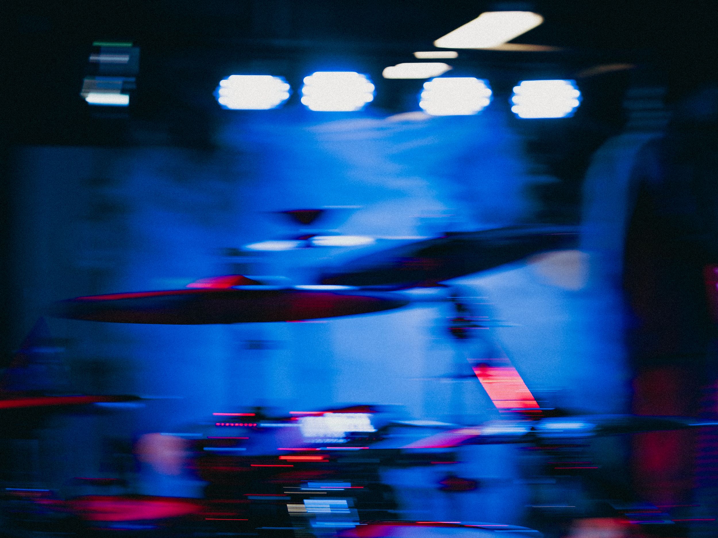 Concert stage lighting creates abstract blue and red motion blur effects during live performance.