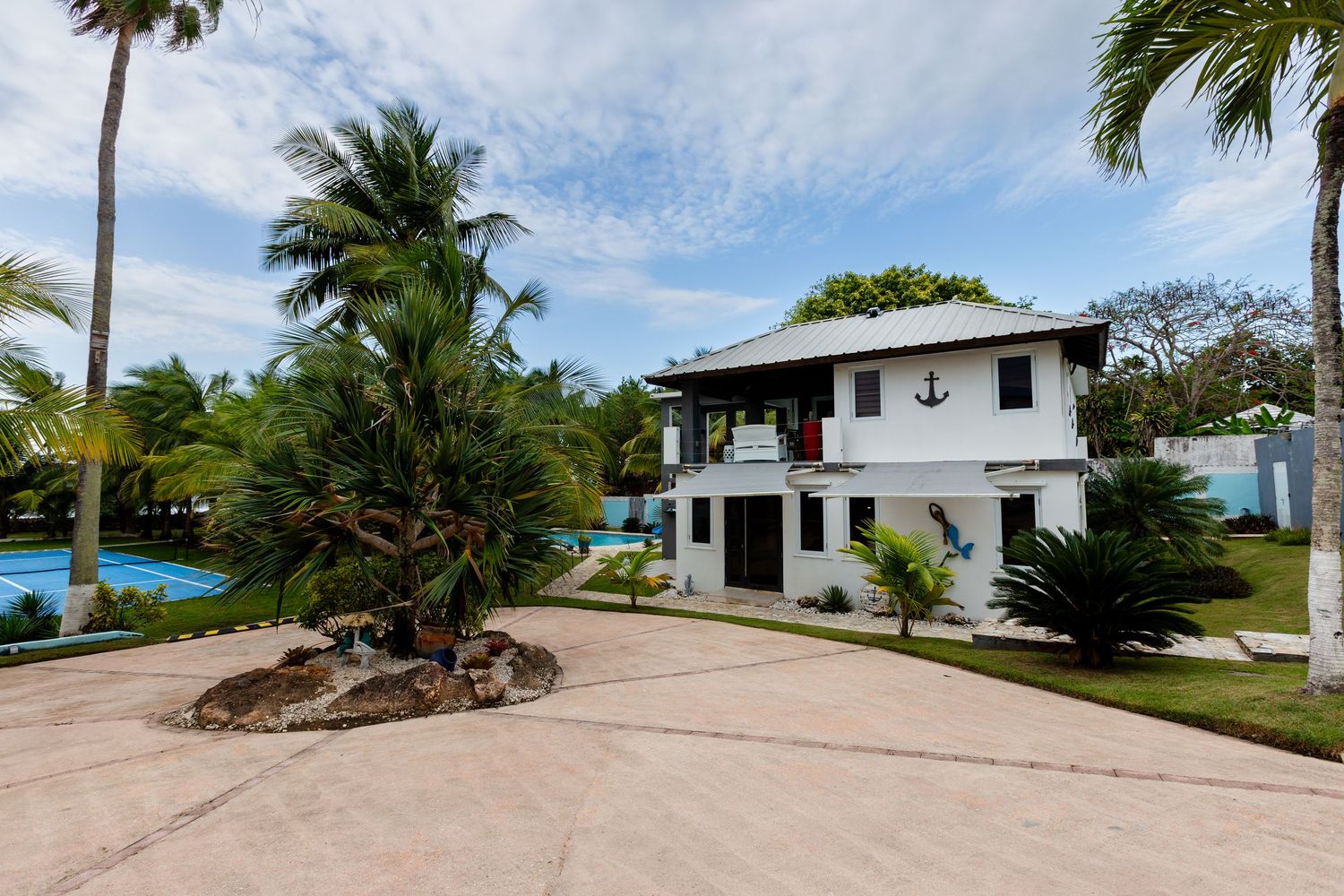 Front of house, tennis court, and pool. Beach house in Vega Baja, Puerto Rico.