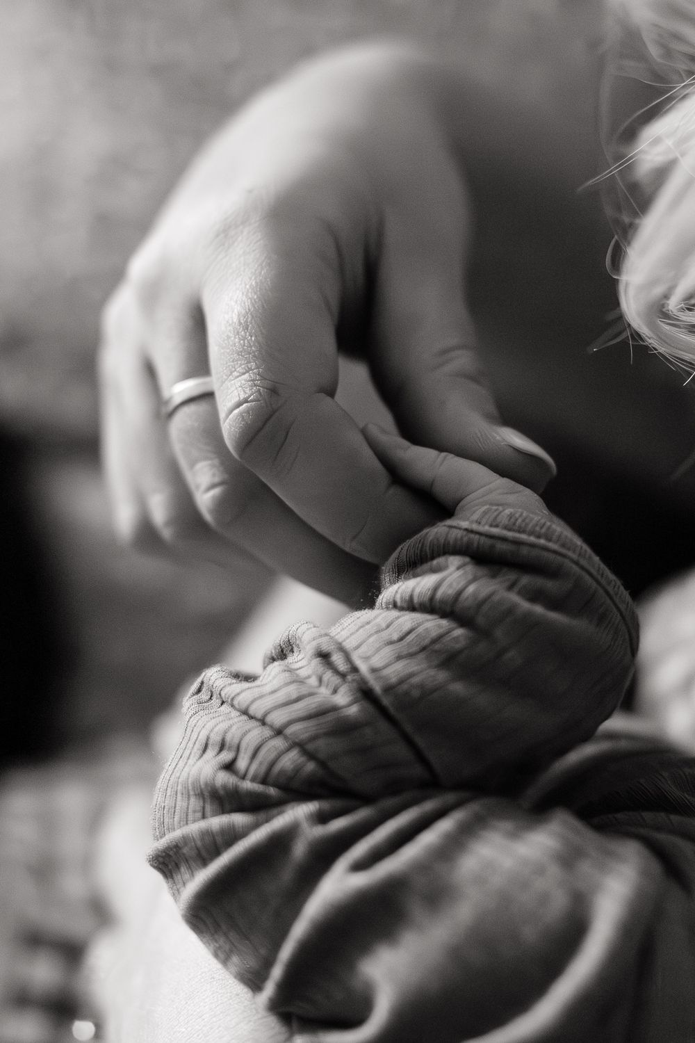 mother's hand holding newborn baby feet