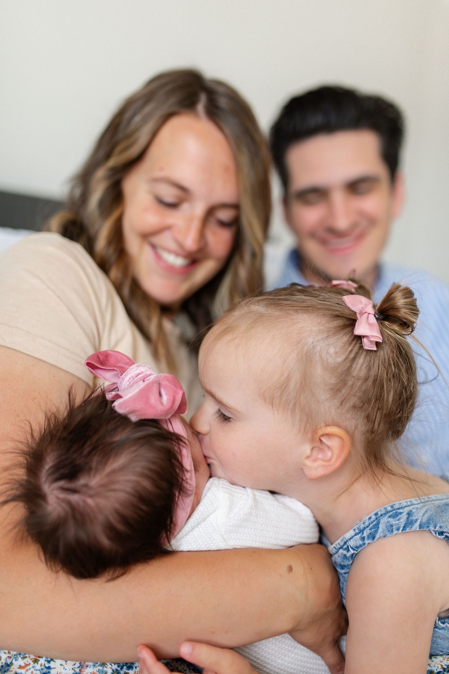 Big sister kissing her newborn baby sister during an O'Fallon MO lifestyle session