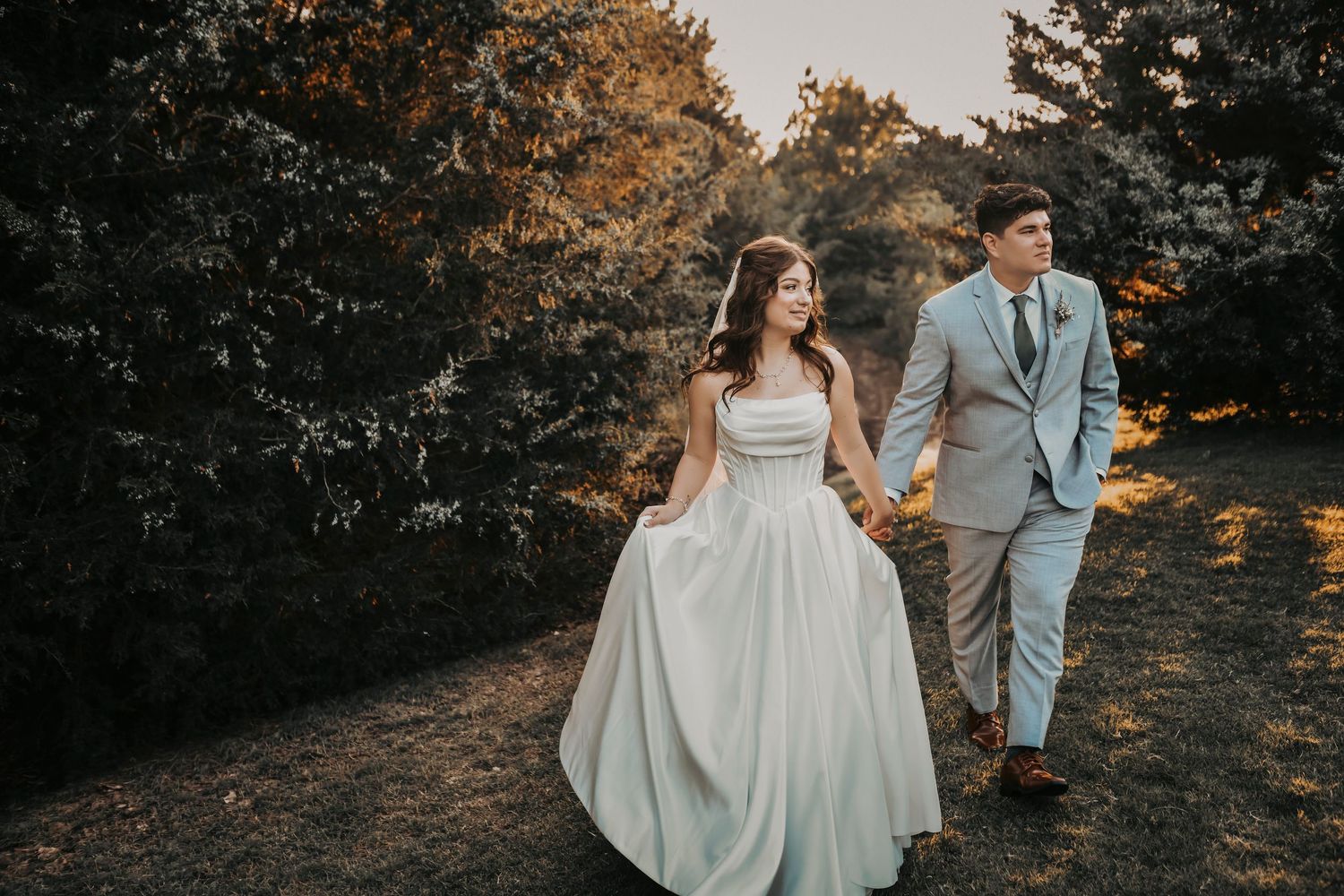 newlyweds walk candidly in the sunset during their cocktail hour at the laurel wedding venue