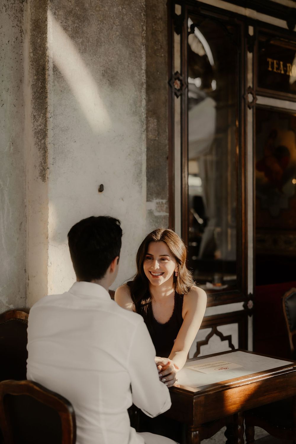 Couple sharing an intimate moment under the historic arcades of Piazza San Marco, Venice.
