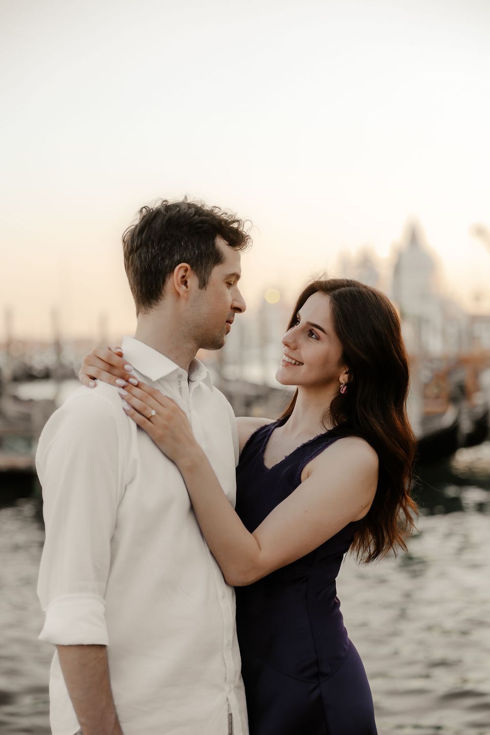 Elegant couple standing between the historic columns of San Marco square during a Venice photo session.