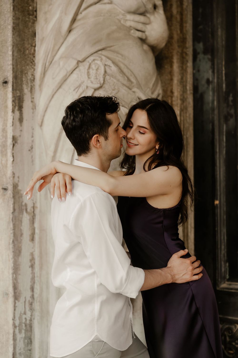Intimate portrait of an international couple with the historic Hotel Danieli and gondolas in the background, Venice.