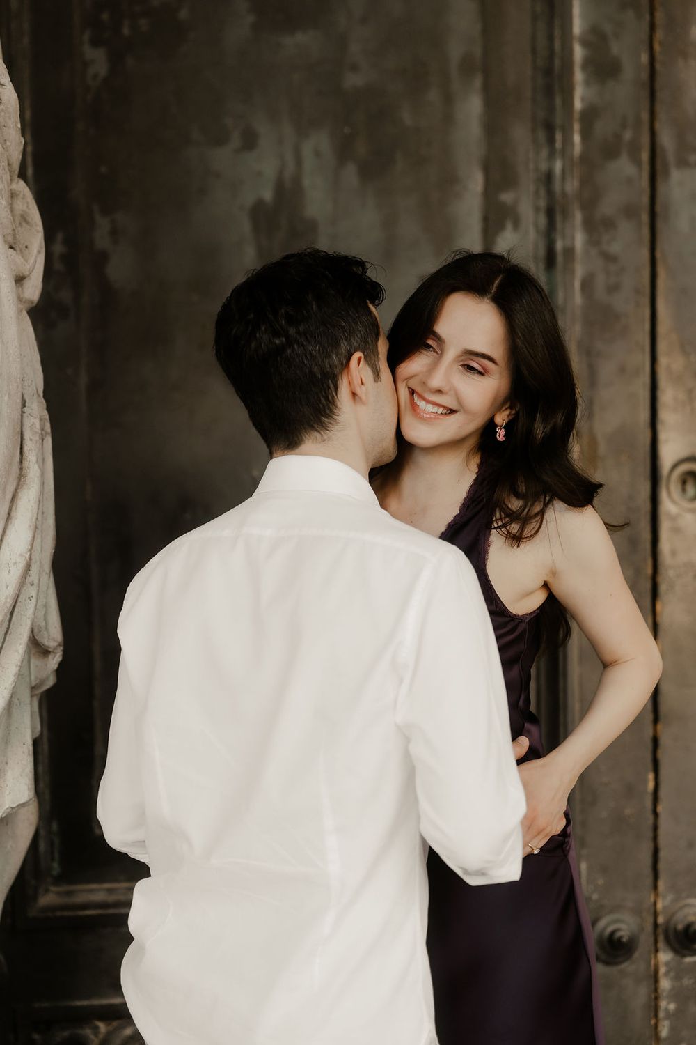 Candid moment of an international couple laughing under the arches of Piazza San Marco.