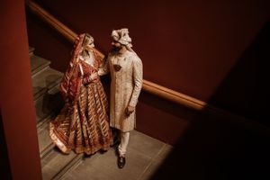 Couple walking through a dimly lit hallway during a wedding celebration.