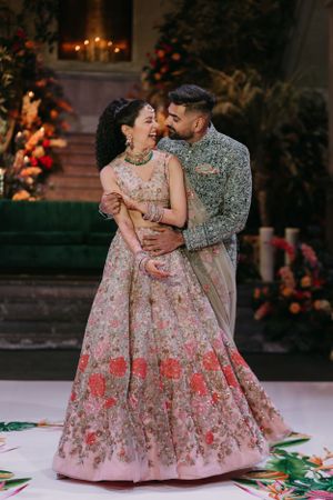 Couple in floral wedding attire share romantic moment on decorated dance floor.