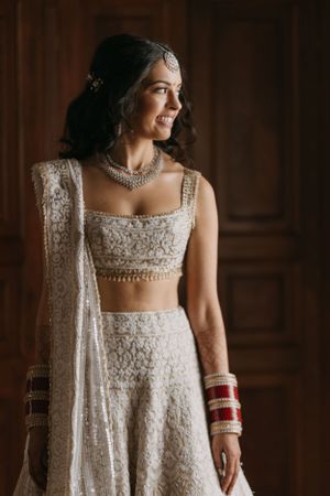 Elegant white embroidered lehenga with crystal details and traditional Indian bridal jewelry.