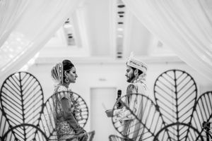Decorative white leaf-shaped panels create an elegant backdrop at an indoor wedding venue.