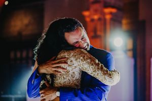 Intimate wedding dance moment captured in warm ambient lighting.