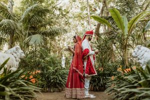 Outdoor wedding photoshoot amidst lush tropical greenery and palm trees.
