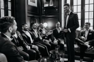 Formal gathering in a luxurious room with dark wood paneling and classic decor.