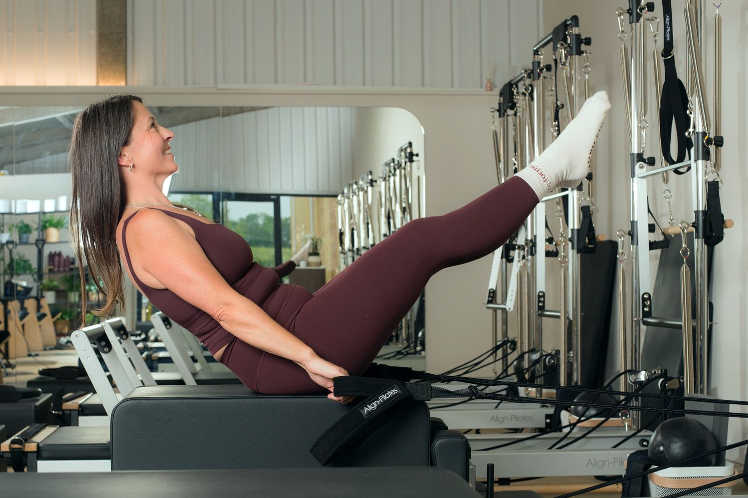 A woman practicing Pilates in a gym during a branding photoshoot by Abigail's studio in Buckinghamshire.