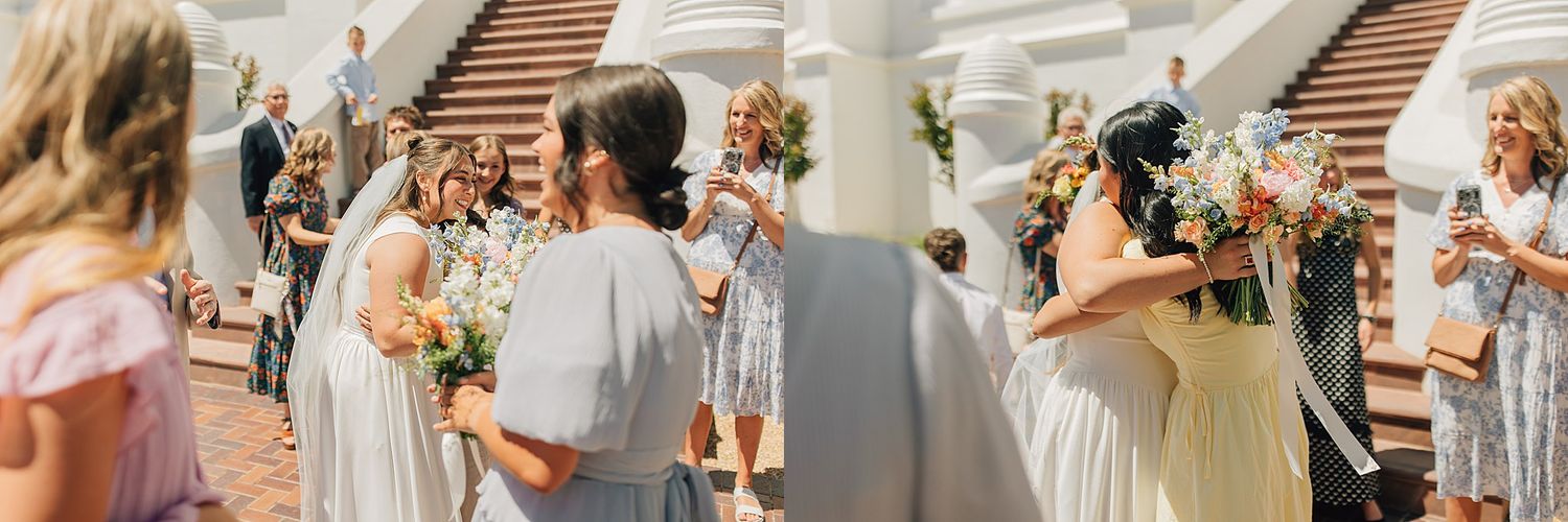 Wedding party celebrates on elegant staircase with bridesmaids in white dresses holding colorful bouquets at an outdoor ceremony.