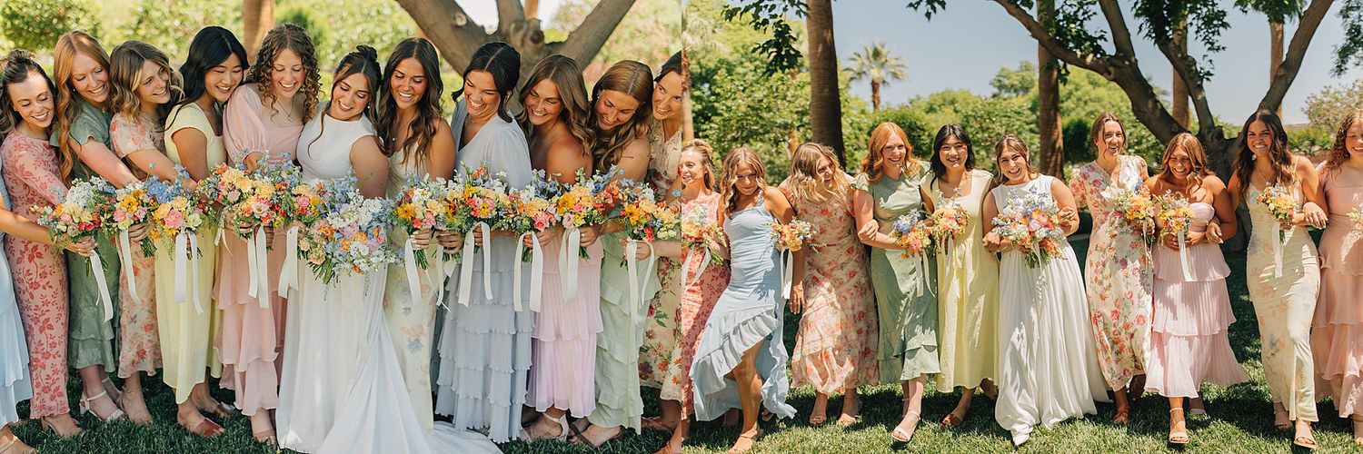 Bridesmaids in mismatched pastel dresses holding bouquets outdoors under green trees on a sunny day.
