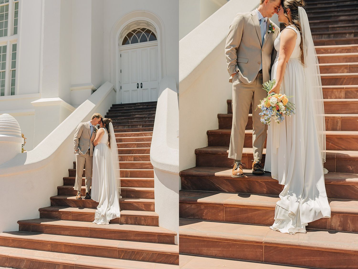 Bride and groom posing on elegant white building stairs, bride in flowing white gown with veil, groom in tan suit.