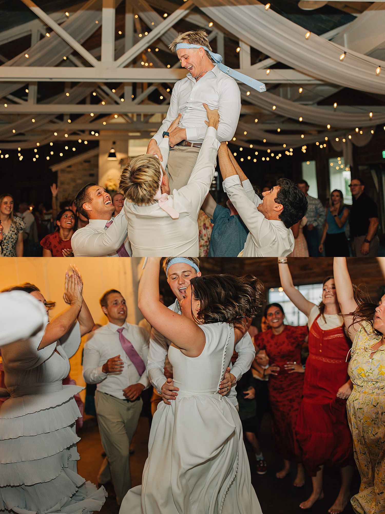 Joyful wedding reception guests lifting a groom in the air while dancing in a rustic barn venue with string lights.