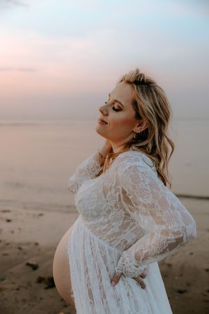 Intieme zwangerschapsshoot vrouw met make-up en styling in Terneuzen, Zeeland, Oost-Vlaanderen. Op het strand met golden hour