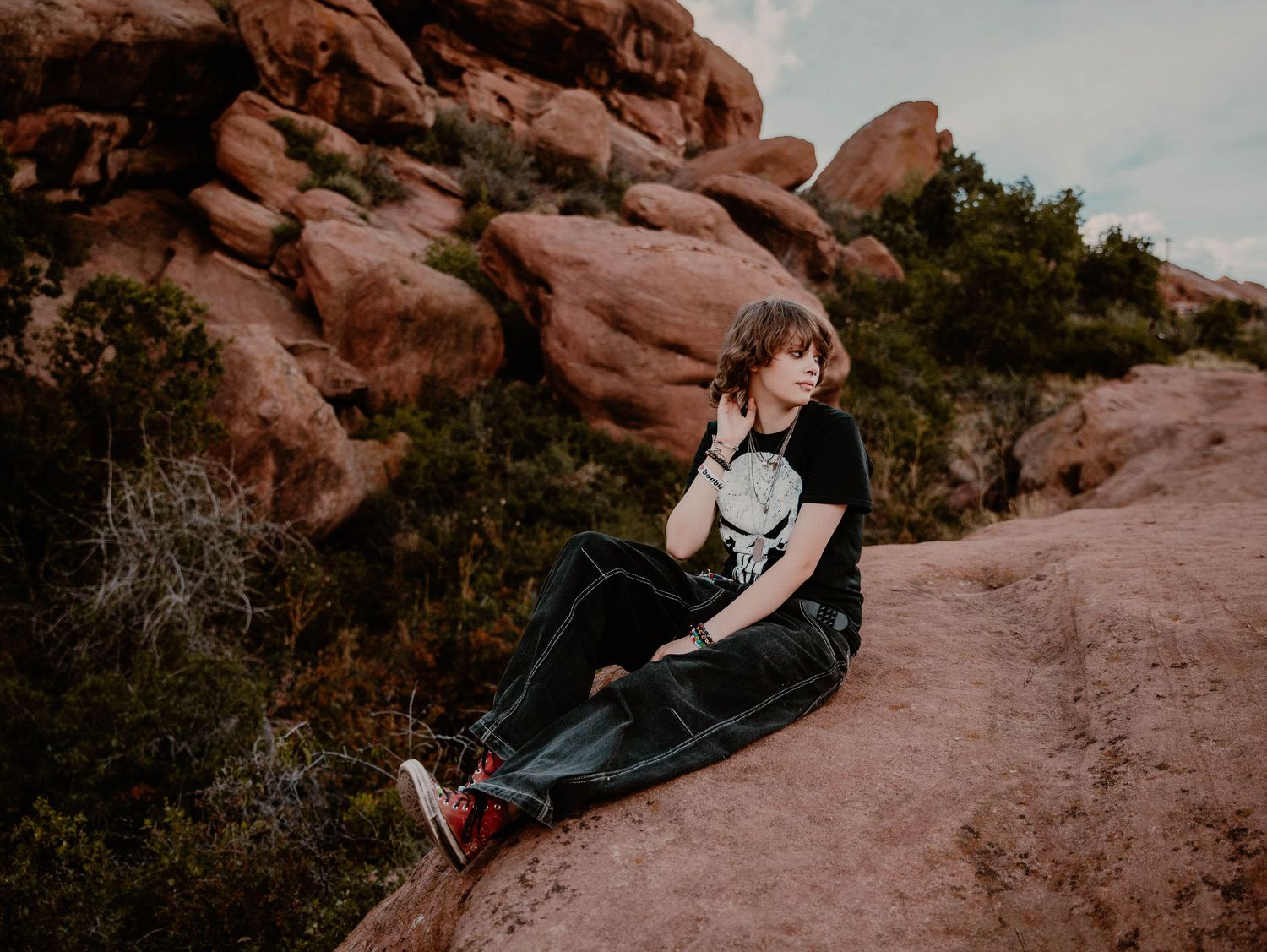 Boy sits down, and poses for senior photos, cinematic, mountain, and portrait photos in Morrison, Colorado outside and in nature