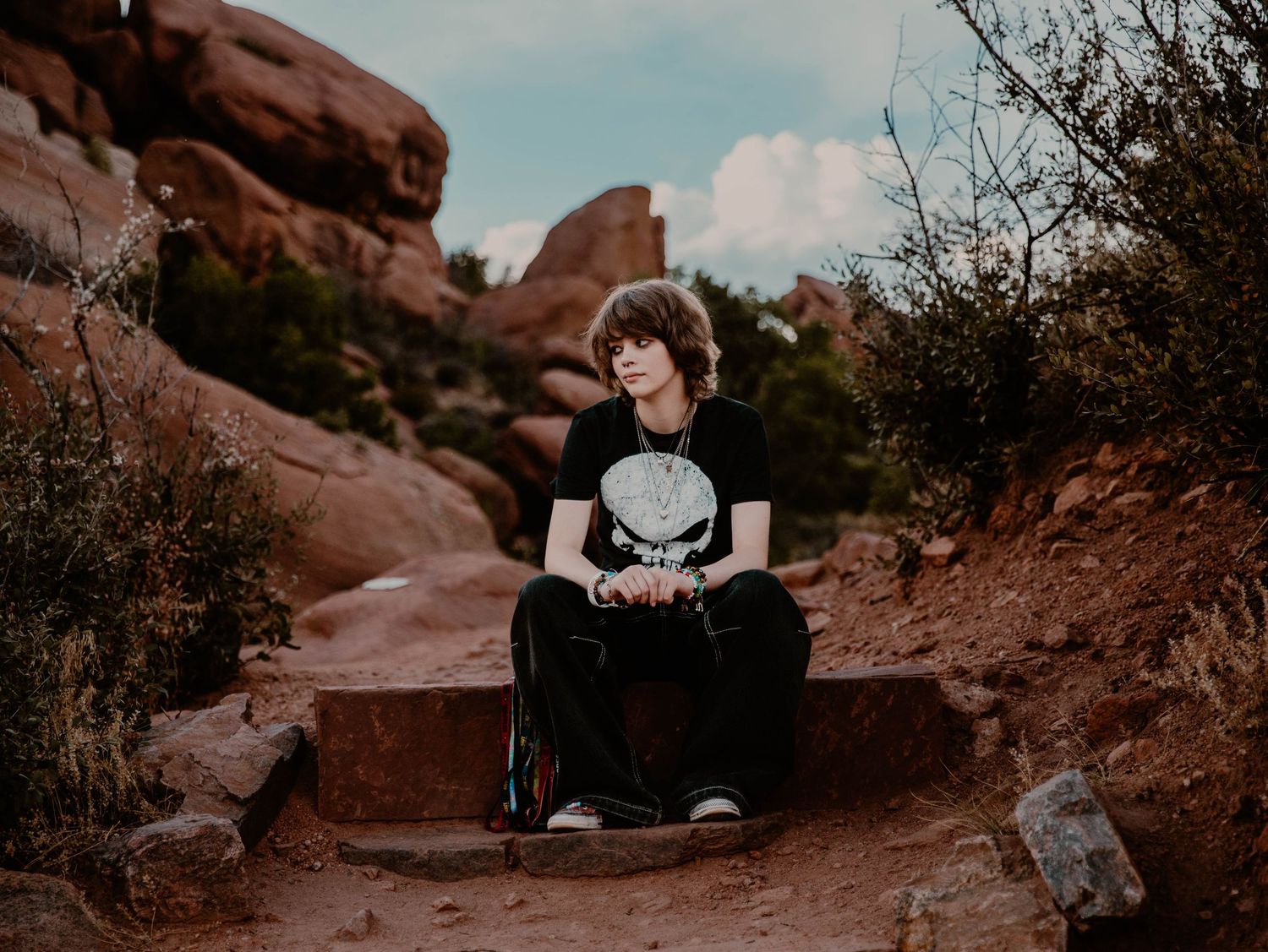 Boy sits down, and poses for senior photos, cinematic, mountain, and portrait photos in Morrison, Colorado outside and in nature