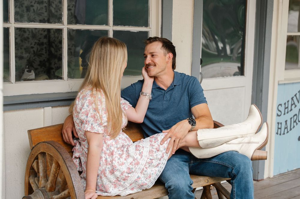 Couple relaxing on a bench outside a vintage shop, sharing a smile.