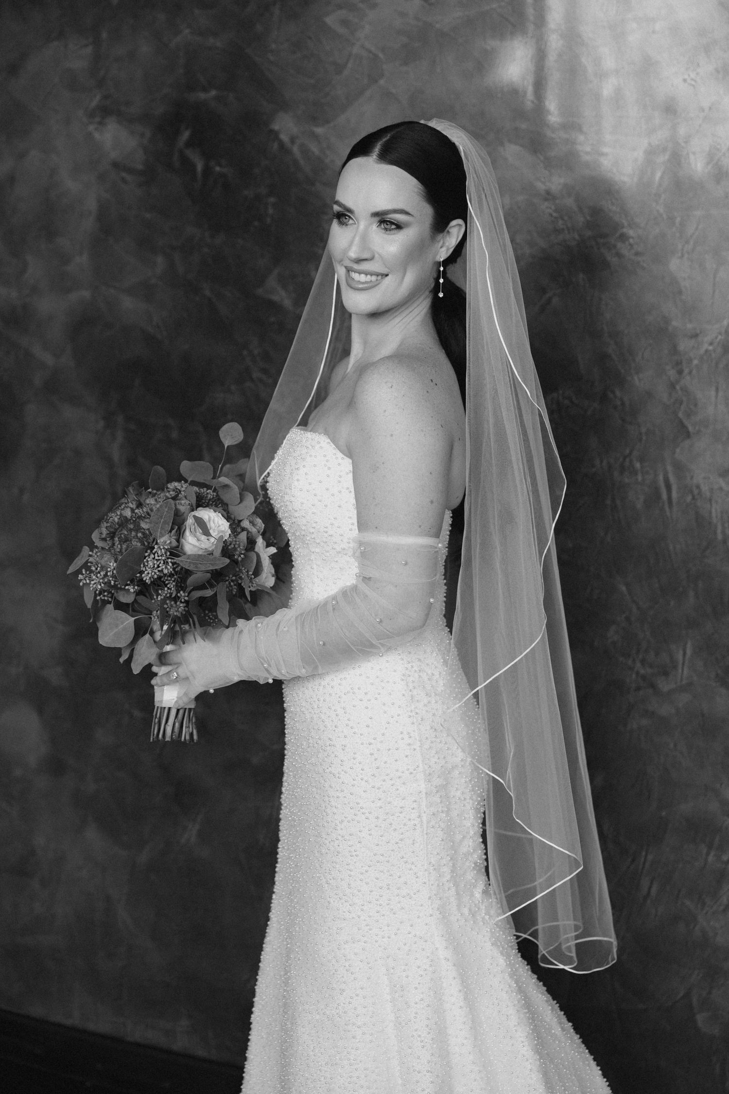 Artistic bridal portrait showing the back of a wedding dress and veil, captured during a wedding day portrait session.