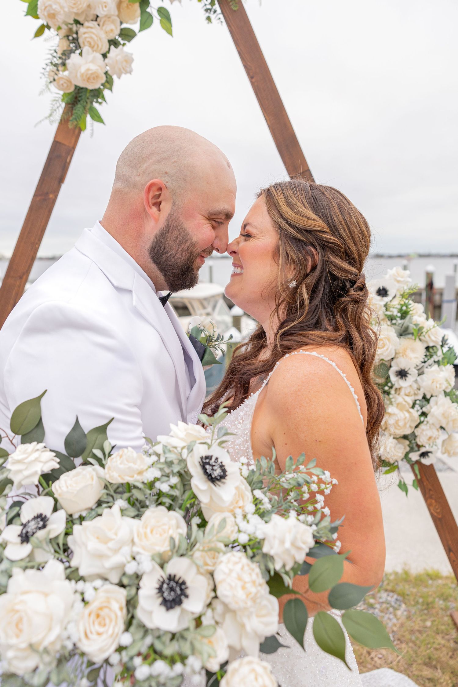 Bride and groom embracing on the beach during a wedding portrait session.