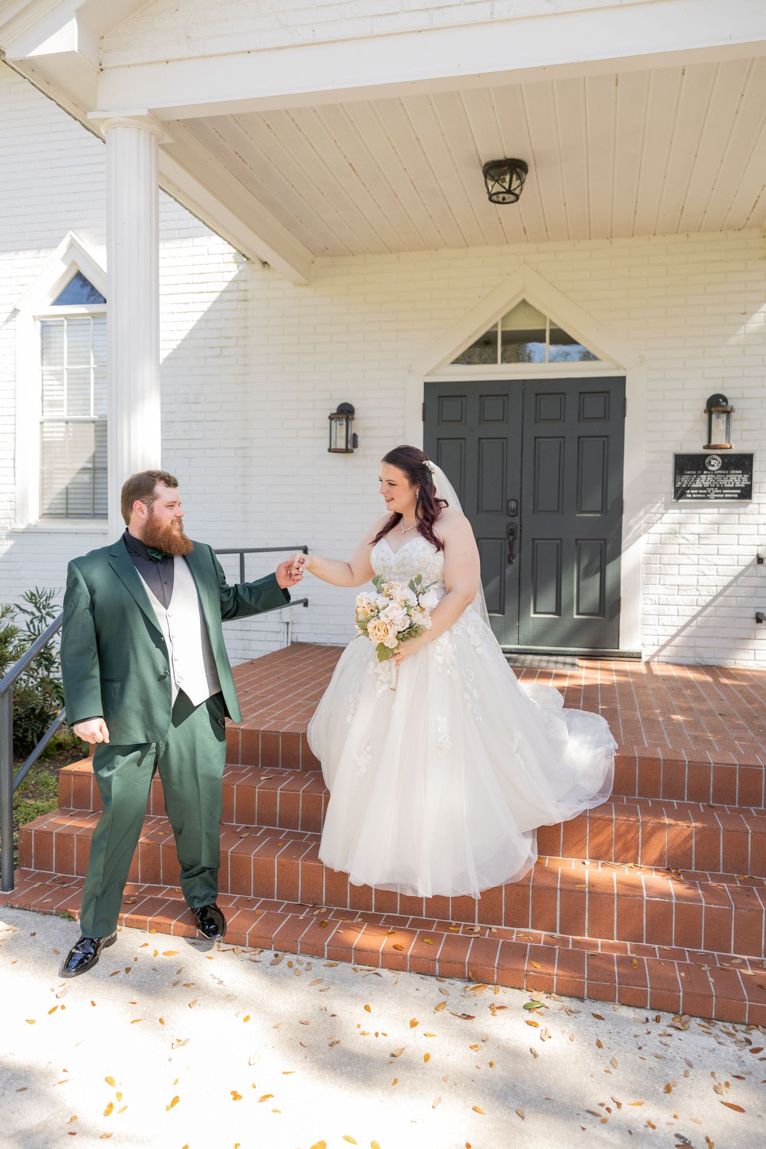 Bride and groom standing together on outdoor steps during their wedding day.