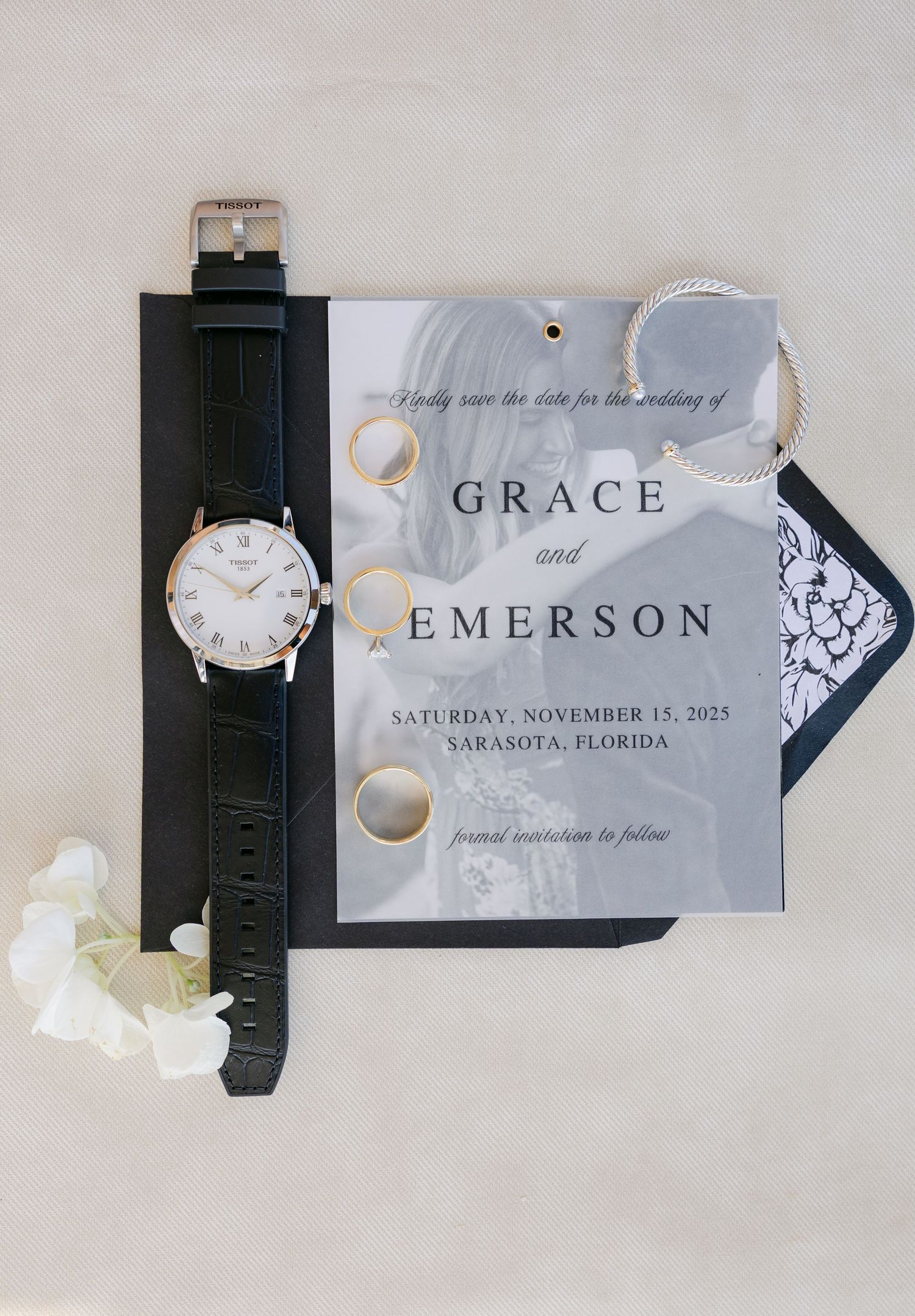 Flat lay of wedding invitation suite and perfume bottle styled as elegant wedding day details.