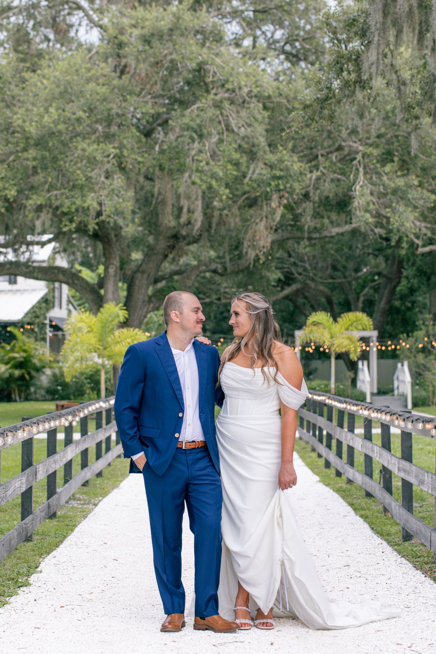 Bride and groom standing together on a bridge during an outdoor wedding portrait session.
