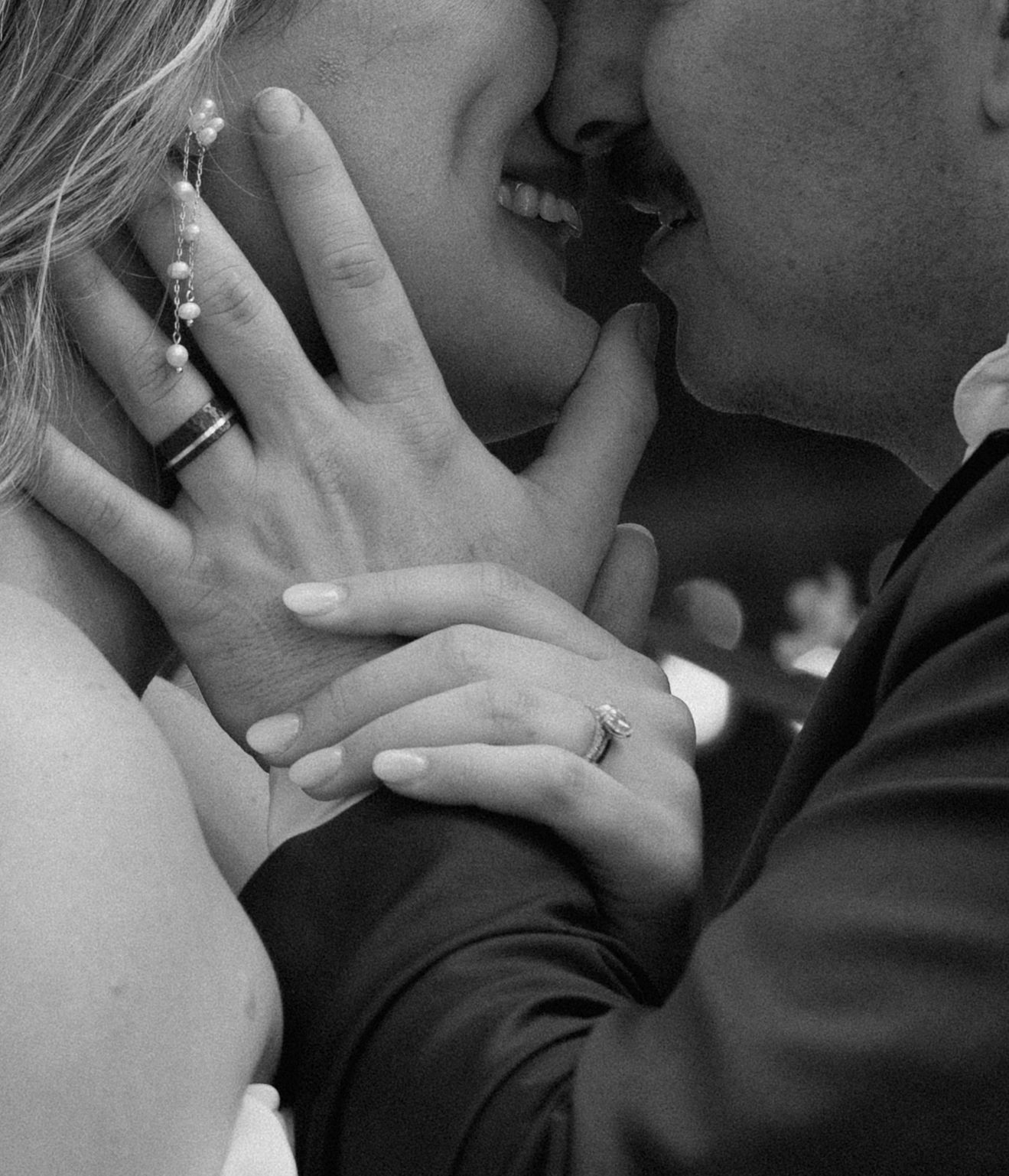 Black and white wedding portrait of a bride and groom embracing.