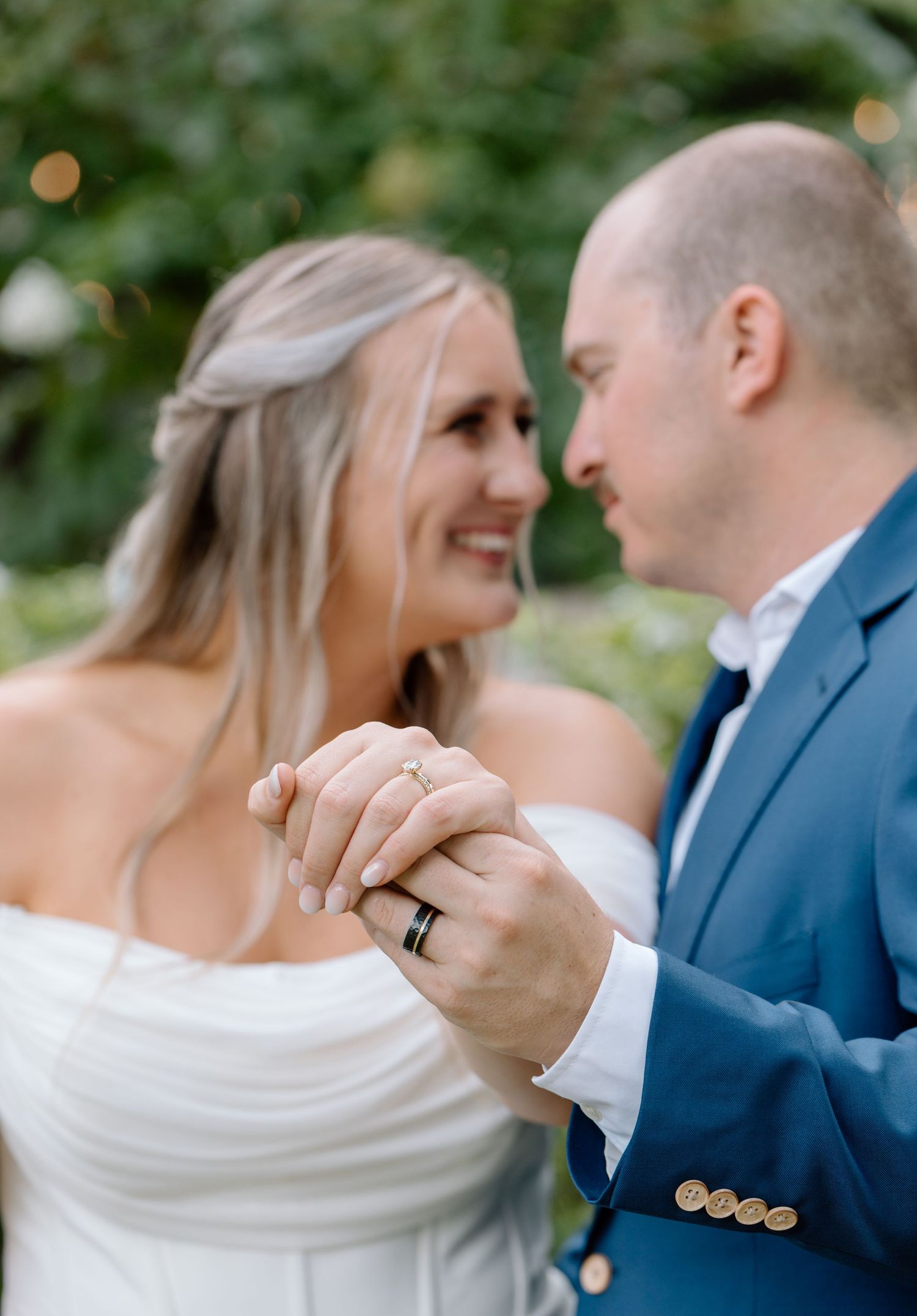 Bride and groom smiling and laughing together during a candid wedding portrait.