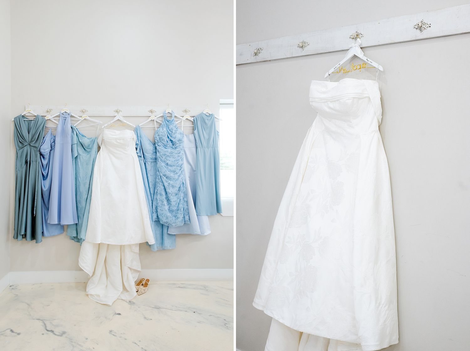 White wedding gown and blue bridesmaid dresses hanging on a rack in a bright white bridal suite.