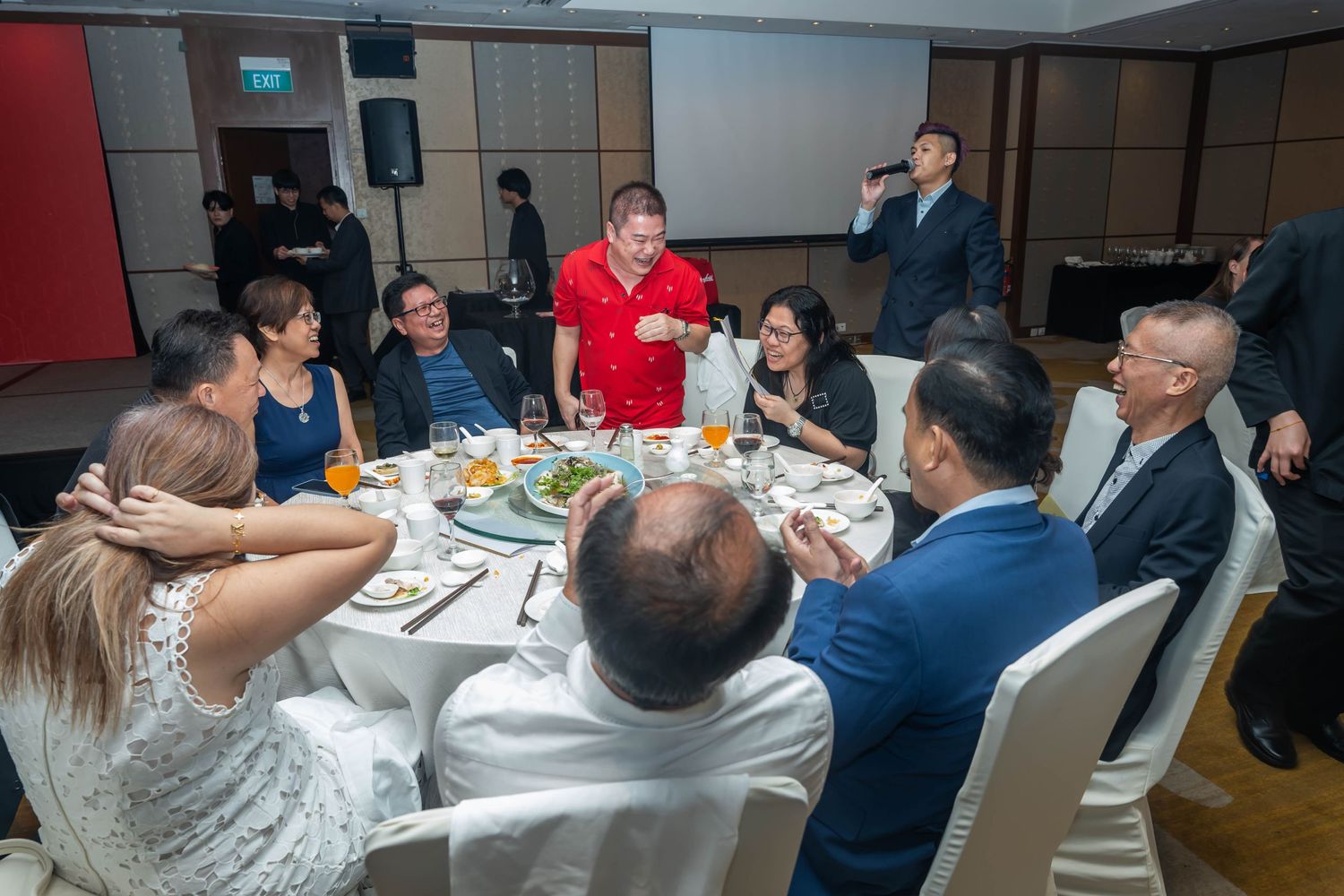 Guests enjoying conversation and dining around a table at formal corporate event.