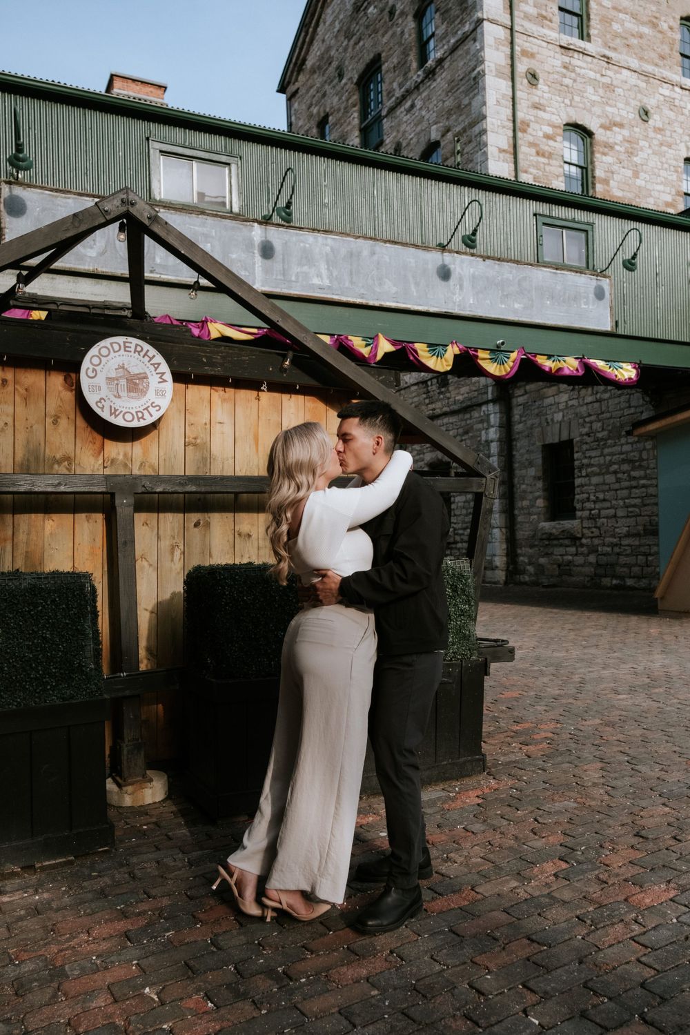 A tender embrace on cobblestone streets in front of historic architecture.