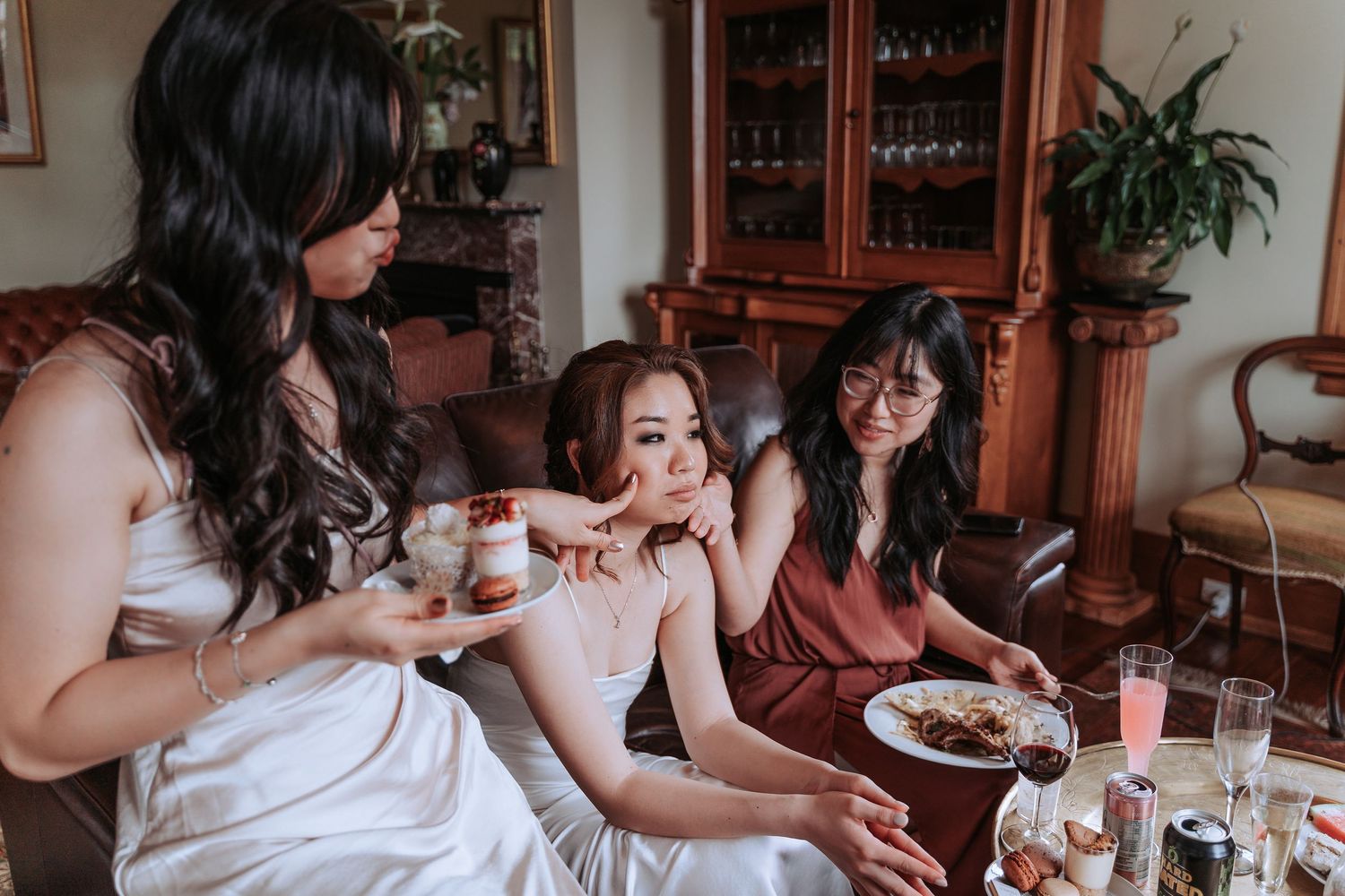 Group enjoys drinks and conversation at an indoor gathering with wooden furniture.
