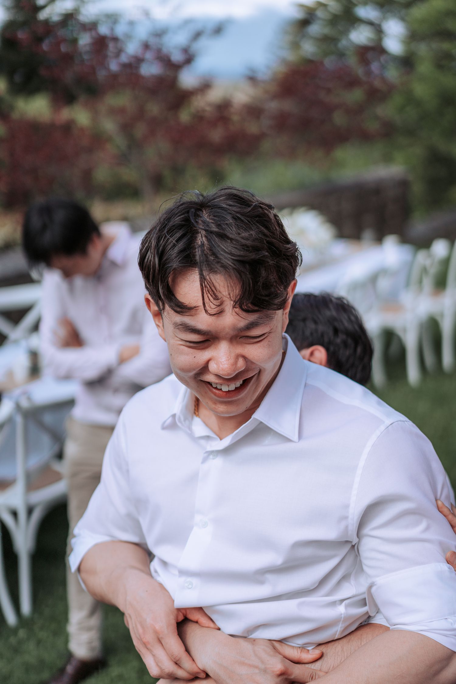 Candid moment captured during outdoor garden party with white dining setup.