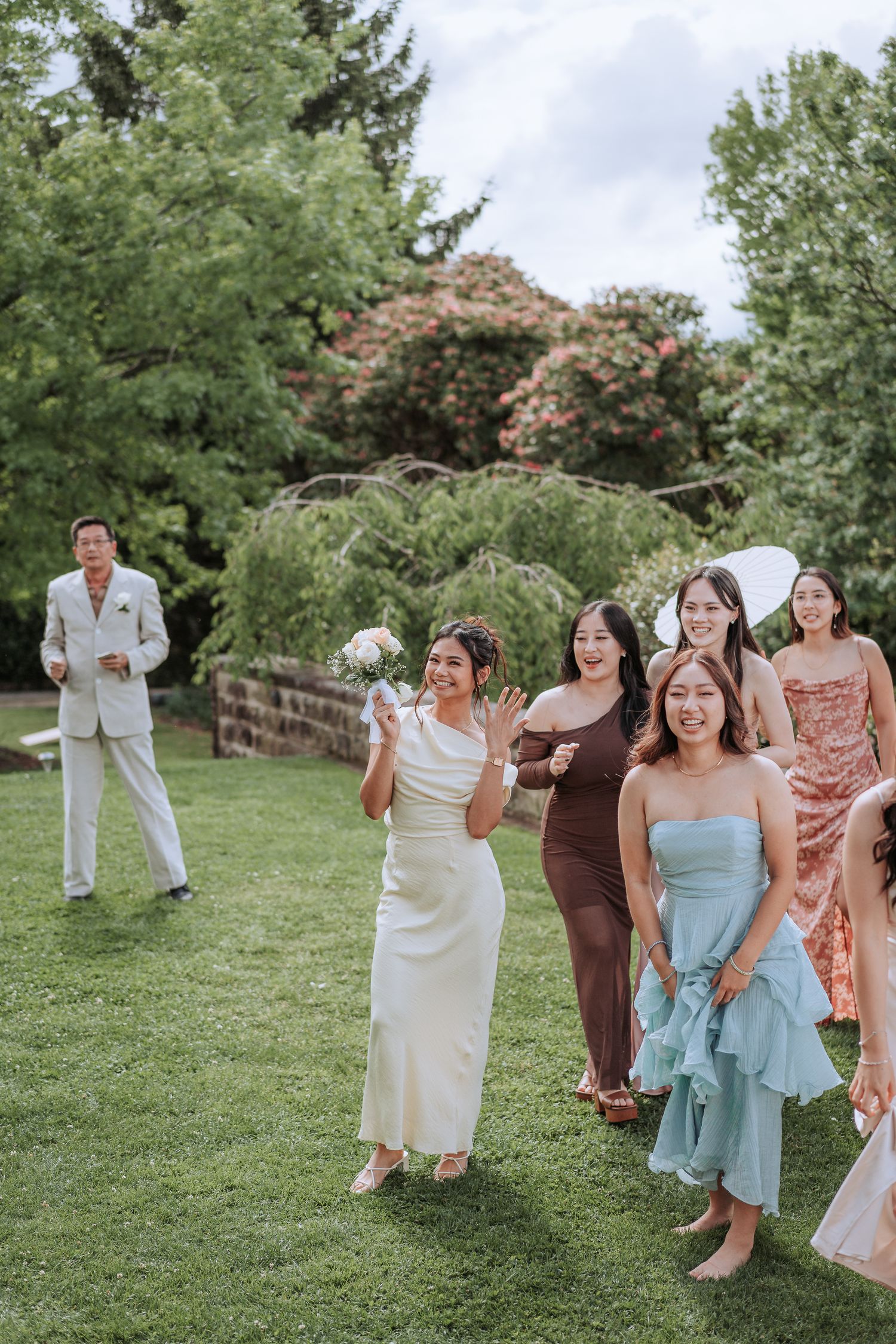 Garden party scene with guests in pastel dresses and formal attire.