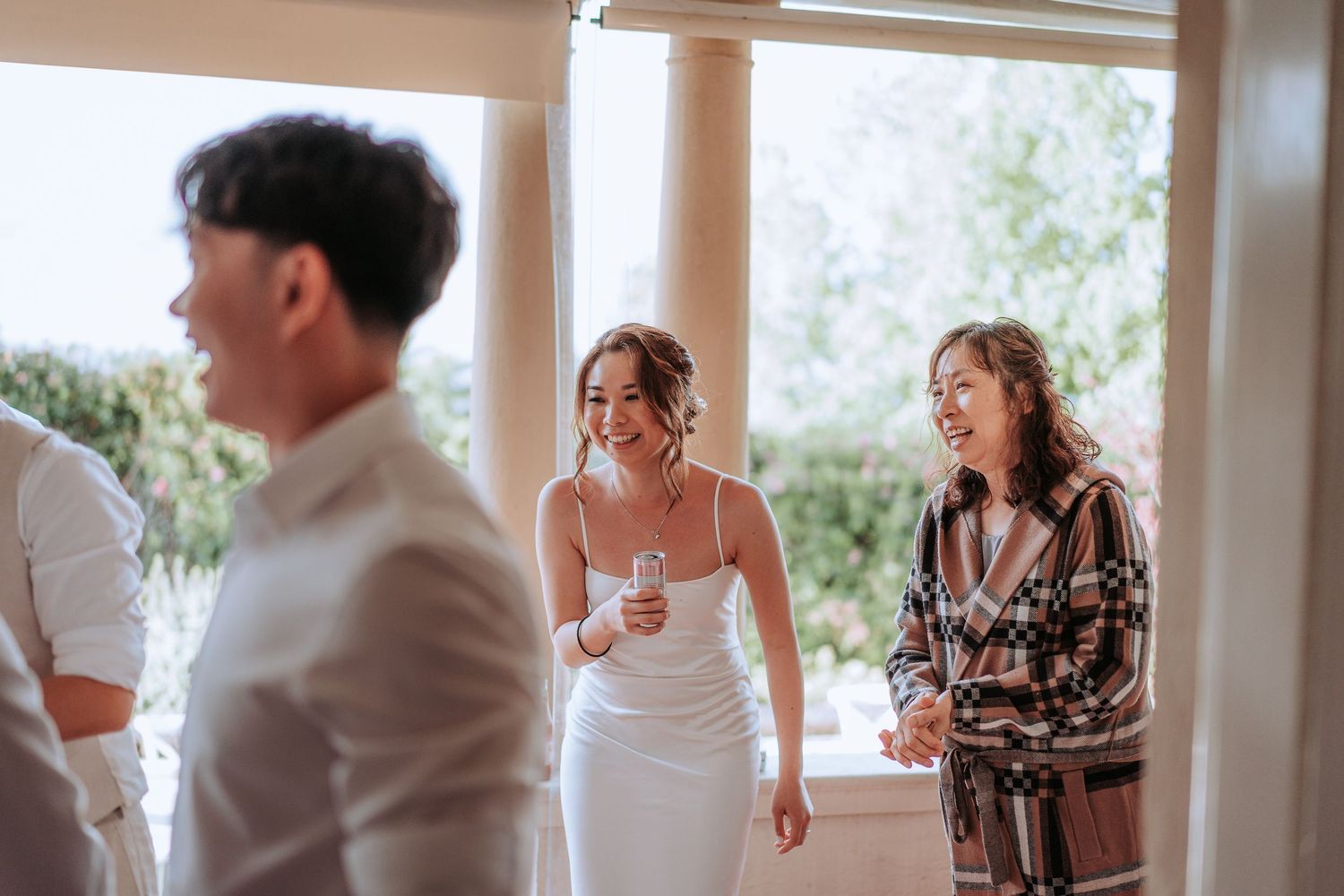 Wedding celebration in progress on covered porch with columns.