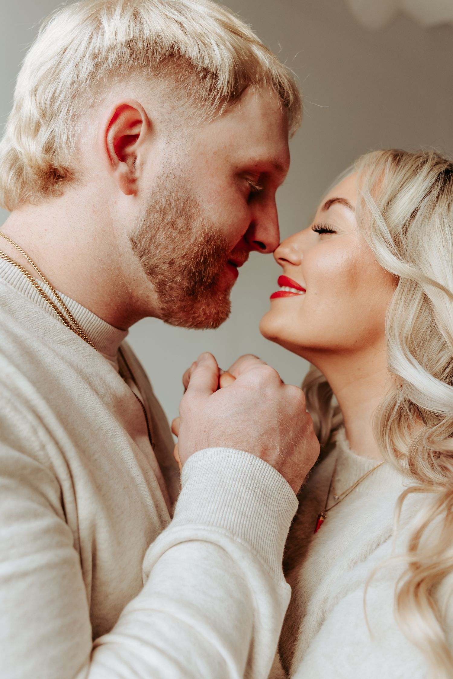 Intimate couple in beige sweaters sharing a tender romantic moment.
