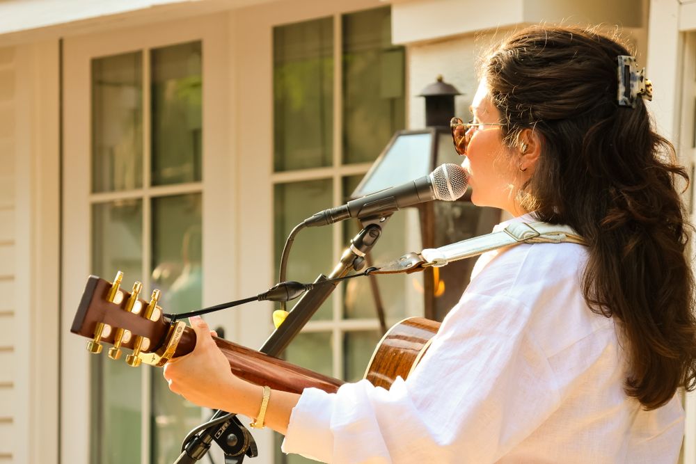 A woman singing and playing guitar.