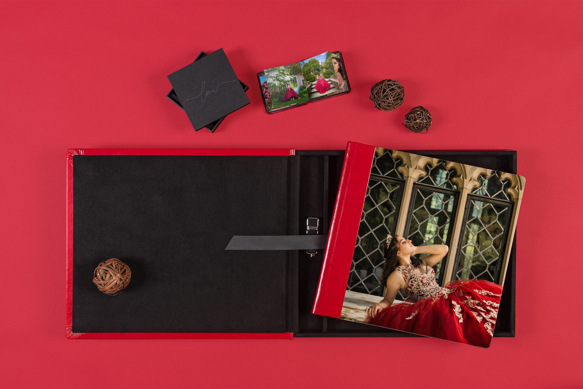 Elegant black photo album with prints displayed on red background.