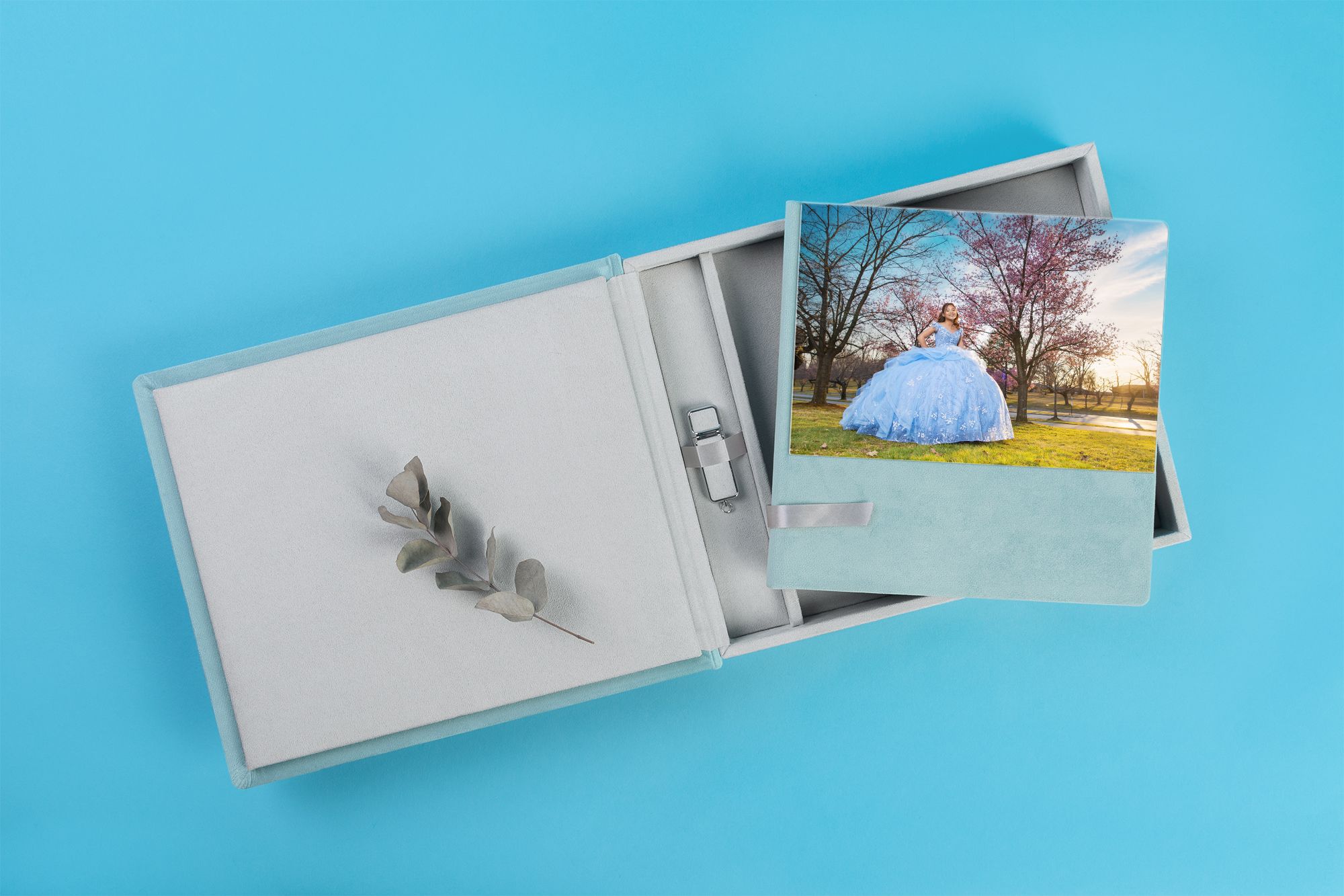Gray photo album with prints displayed on light blue background.