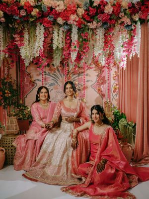 Traditional wedding scene with decorative floral backdrop featuring red and white cascading flowers and elegant attire.