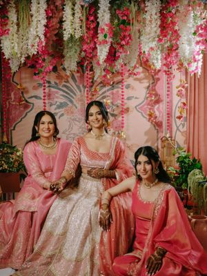 South Asian traditional event featuring elegant pink and silver decor with hanging floral arrangements in white and pink.