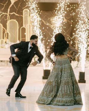 A couple dancing at a wedding celebration with sparklers creating a magical backdrop on the dance floor.