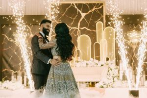 A romantic dance moment captured under sparkling lights with an ornate ball gown and formal attire.