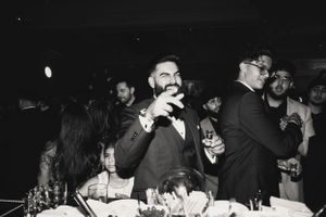 A black and white photo showing guests enjoying a festive celebration at a dinner party.