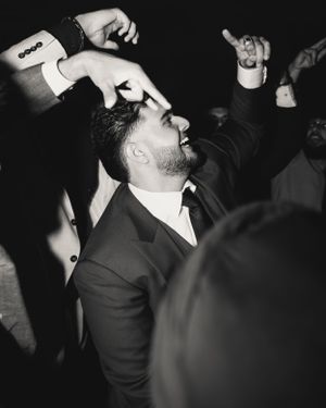 Black and white photo of people dancing and celebrating at what appears to be a formal event.