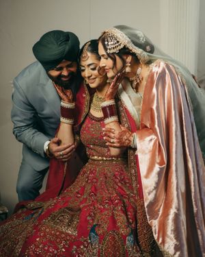 Intimate family moment during an Indian wedding ceremony with traditional red bridal attire.